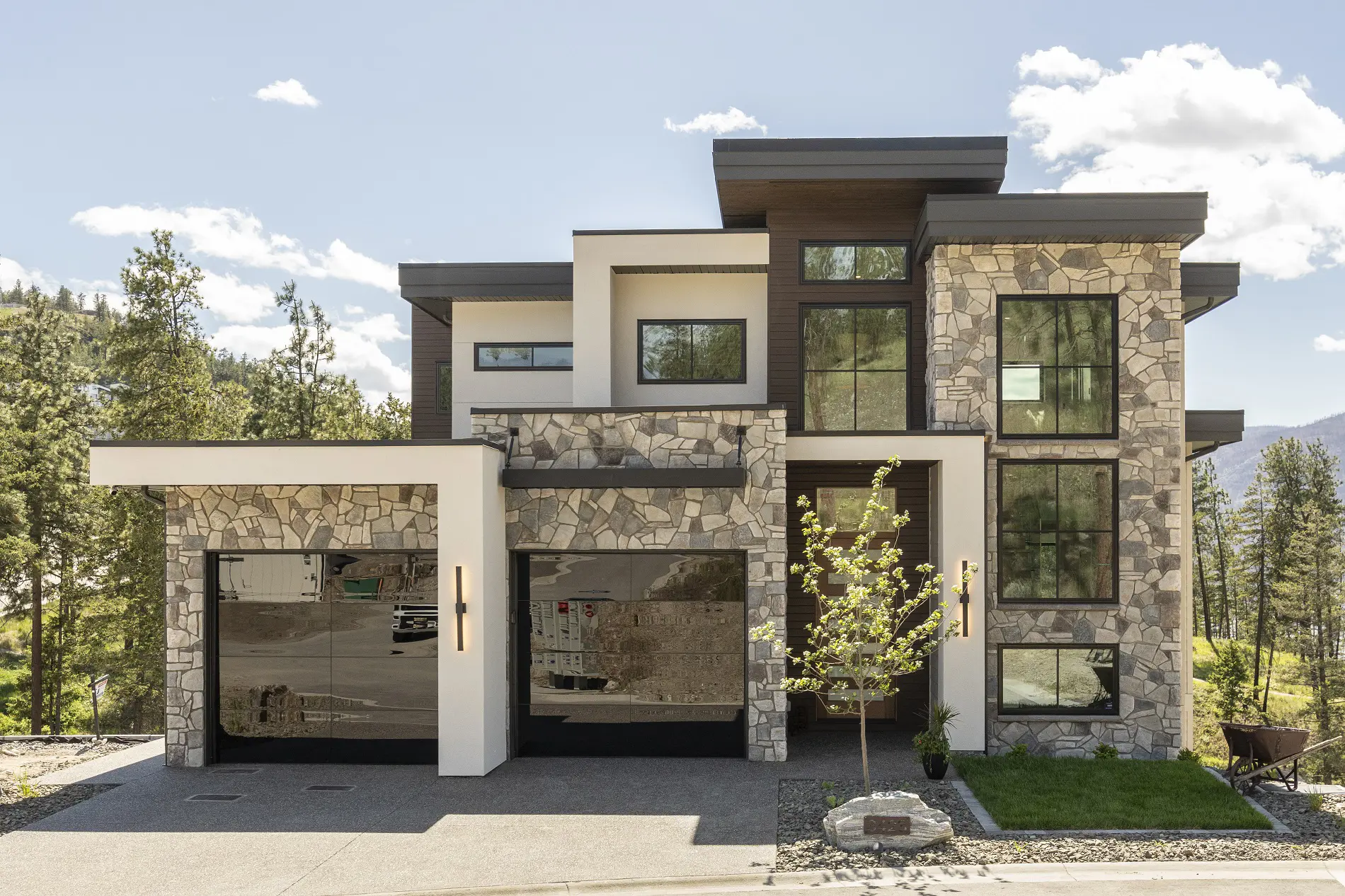 A beautiful modern Okanagan home with a stone effect and sleek black hybrid Supreme windows with grids.